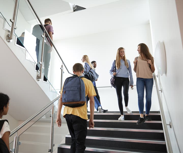 High school students walk on a stairwell in an education facility 