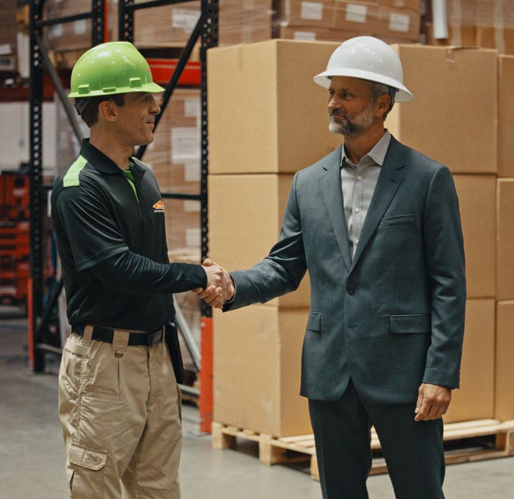 A SERVPRO employee and an insurance representative shaking each other's hands.
